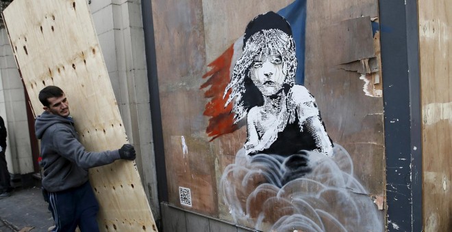 Un trabajador carga con un tablón para tapar el nuevo grafiti de Banksy en Londres.-  REUTERS/Stefan Wermuth