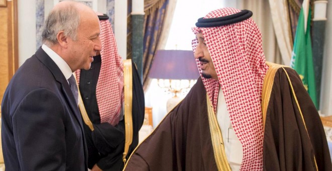 El rey Salman da la mano al ministro de Relaciones Exteriores francés, Laurent Fabius en Riad. REUTERS