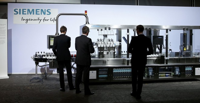 Varias personas en un stand de Siemens expuesto en la junta general de accionistas del gigante alemán, la pasada semana. REUTERS/Michael Dalder