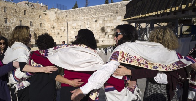 Mujeres con chales de oración cantan mientras caminan hacia la sección reservada para ellas del Muro de las Lamentaciones, en Jerusalén. EFE / EPA / JIM HOLLANDER