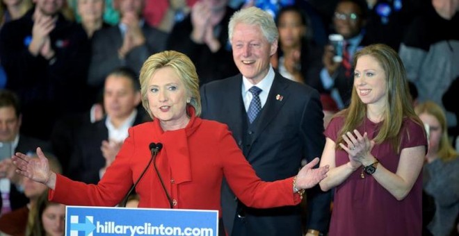La candidata presidencial de partido Democráta Hillary Clinton habla junto a su esposo, el expresidente de EE.UU Bill Clinton, y su hija Chelsea Clinton durante la noche del caucus del partido Demócrata./ EFE