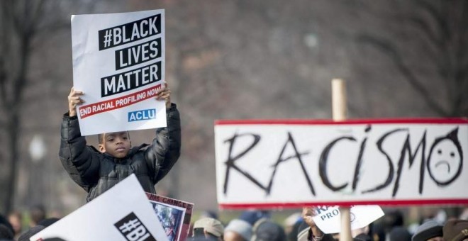 Un niño sostiene una pancarta en una protesta en Washington por las muertes de dos negros a manos de policías blancos. EFE