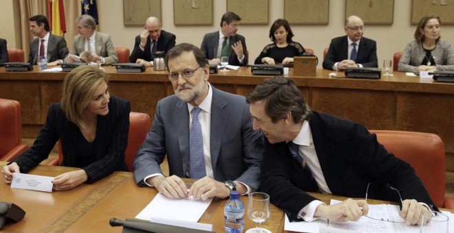 El presidente del Gobierno en funciones, Mariano Rajoy, junto a la secretaria general del PP, María Dolores de Cospedal, y el portavoz del partido en el Congreso, Rafael Hernando, durante la reunión que ha mantenido hoy con los diputados de la formación.