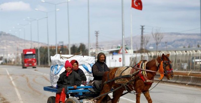 Una familia viaja en un carromato, cerca de la frontera entre Siria y Tuqriía, en la ciudad de Killis.- EFE