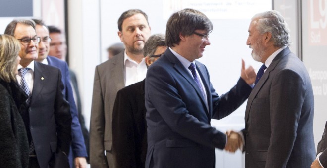 El president de la Generalitat, Carles Puigdemont, saluda al secretario de Estado de Infraestructuras, Julio Gómez-Pomar, en presencia del vicepresidente del Gobierno catalán, Oriol Junqueras y el expresidente de la Generalitat, Arthur Mas, entre otros, m