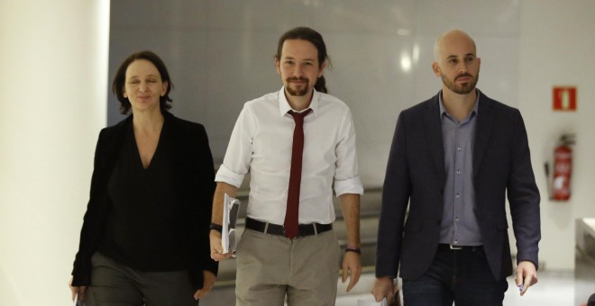 El secretario general de Podemos, Pablo Iglesias, acompañado por el portavoz económico del partido, Nacho Álvarez, y la diputada Carolina Bescansa, antes de presentar en el Congreso su oferta de programa de gobierno de coalición con el PSOE. EFE/Zipi