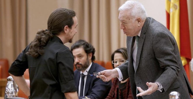 El ministro de Exteriores en funciones, José Manuel García-Margallo, conversa con el líder de Podemos, Pablo Iglesias. - EFE