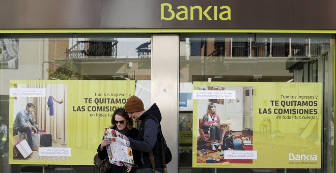 Dos turistas consultan un mapa frente a una oficina de Bankia en Sevilla. REUTERS/Marcelo del Pozo
