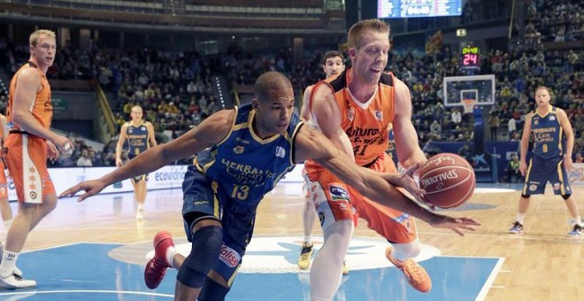 El alero dominicano del Herbalife Gran Canaria Eulis Báez (i) lucha el balón con Justin Hamilton, del Valencia Basket, durante el partido de la segundo eliminatoria de los cuartos de final de la Copa del Rey de baloncesto que se disputa hoy en el Coliseum