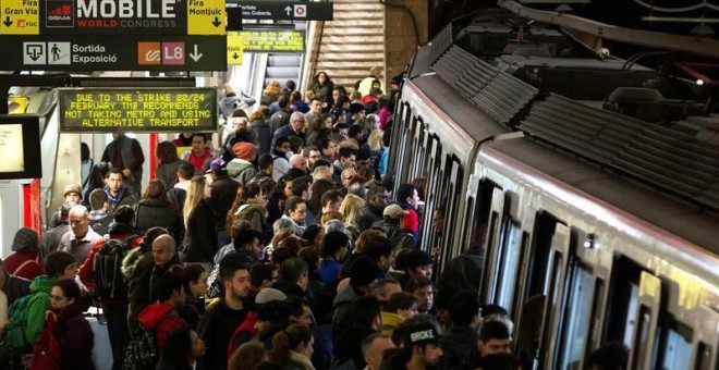 Usuarios del Metro de Barcelona esperan en el andén de la estación de Plaza España la llegada de un convoy. / QUIQUE GARCÍA (EFE)