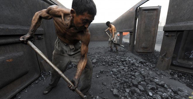 Los trabajadores trabajan con el carbón en una estación de ferrocarril en la provincia de Hefei, Anhui. REUTERS / Jianan Yu / Archivos