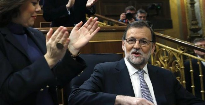 El presidente del Gobierno en funciones y líder del PP, Mariano Rajoy (d), ha sido recibido con un estruendoso aplauso por los diputados de su grupo al entrar al hemiciclo del Congreso, donde inaugura la segunda jornada del debate de investidura del líder