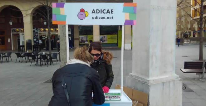 La organización de consumidores y usuarios Adicae recoge firmas para denunciar abusos con las comisiones ante una oficina de Bankia en Zaragoza.