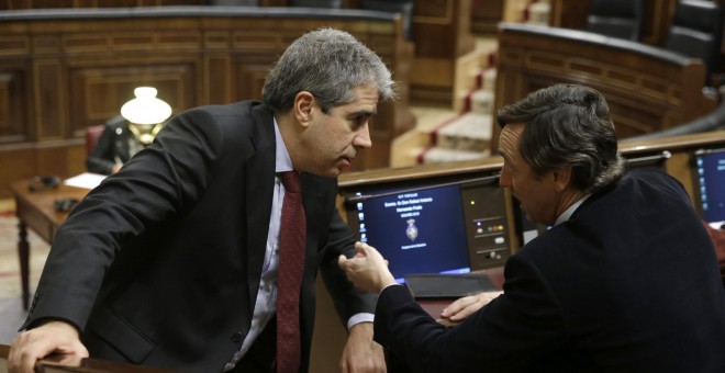 El portavoz de Democràcia i Llibertat (DiL), Francesc Homs (i), conversa con el portavoz del PP, Rafael Hernando (d), durante la sesión de la tarde de la segunda jornada del debate de investidura del secretario general del PSOE, Pedro Sánchez, que se cele