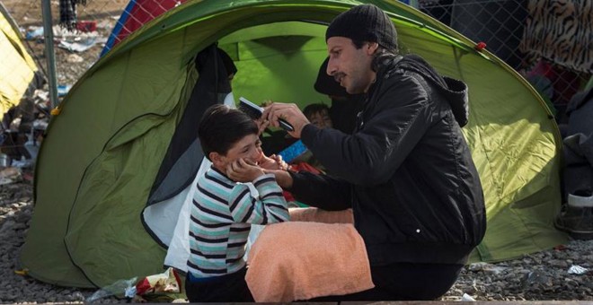 Unos refugiados esperan al norte de Grecia entrar en Macedonia.- EFE