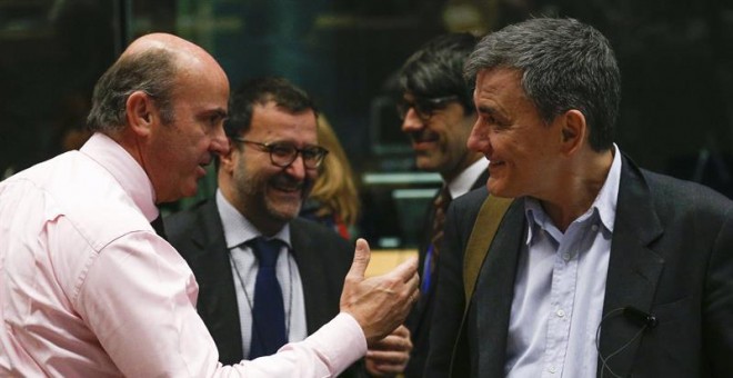 El ministro español en funciones de Economía Luis de Guindos saluda al ministro heleno de Finanzas, Euclides Tsakalotos durante el encuentro de ministros de Economía y Finanzas del euro. EFE