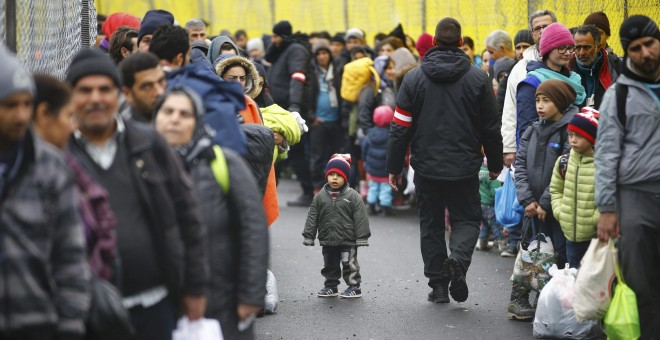 Decenas de personas esperan, cargados con sus pocos enseres, a poder cruzar la frontera de Eslovenia para llegar a Spielfeld, Austria.- REUTERS