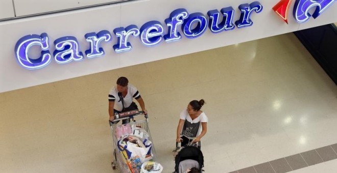 Una pareja sale de realizar sus compras en un hipermercado de Carrefour cerca de París. REUTERS/CHARLES PLATIAU