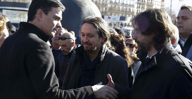 El secretario general del PSOE, Pedro Sánchez (i), saluda al responsable de Relaciones con la Sociedad Civil de Podemos, Rafael Mayoral, en presencia del líder de la formación, Pablo Iglesias, durante el homenaje.- EFE