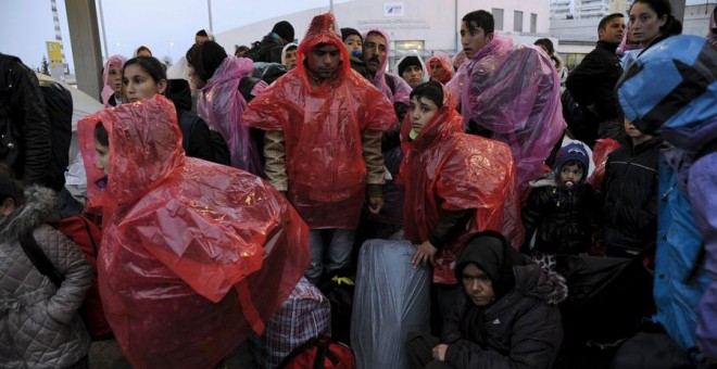 Refugiados tratan de protegerse de la lluvia en el puerto de El Pireo, cerca de Atenas. REUTERS/Michalis Karagiannis