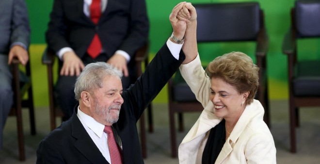 La presidenta de Brasil, Dilma Rousseff, levanta el brazo de su antecesor,  Luiz Inacio Lula da Silva, tras su toma de posesión como ministro de la Presidencia en el Palacio Planalto, en Brasilia. REUTERS/Adriano Machado