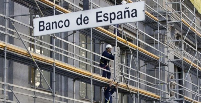 Unos trabajadores montan un andamio en la fachada del edificio del Banco de España, en Madrid. REUTERS