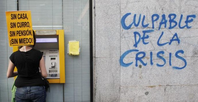 Una participante en una manifestación contra la austeridad, en un cajero automático en Madrid. REUTERS