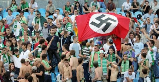 Aficionados ucranianos sujetan una esvástica durante un Dynamo Kiev-Karpaty. - REUTERS