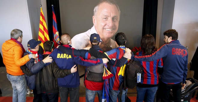 Varios aficionados barcelonistas se abrazan frente a la foto de Johan Cruyff en el memorial instalado en el Camp Nou. REUTERS/Albert Gea