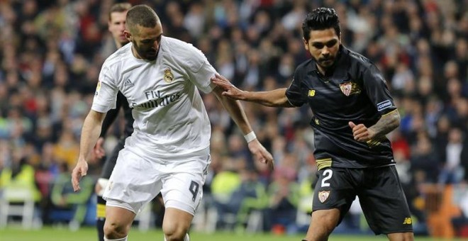 El francés Benoît Trémoulinas, del Sevilla, disputa un balón a Benzema, del Real Madrid, en el último partido de Liga. /EFE