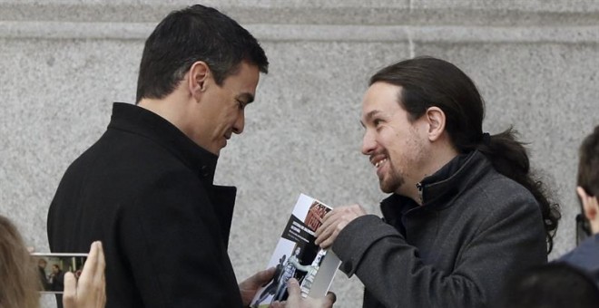 El momento en el que Pablo Iglesas entrega el libro a Pedro Sánchez antes de su reunión. EFE/J. J. Guillén