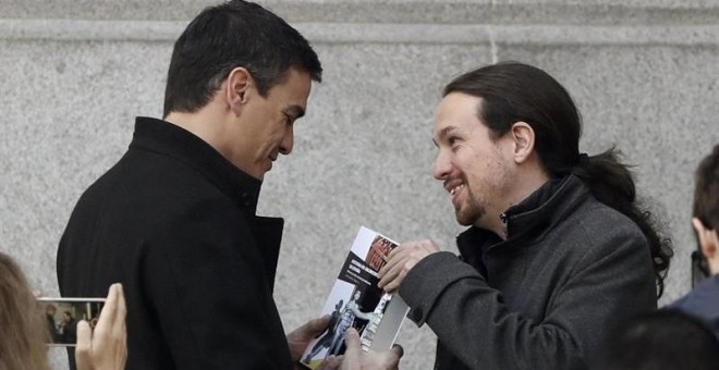 El momento en el que Pablo Iglesas entrega el libro a Pedro Sánchez antes de su reunión. EFE/J. J. Guillén