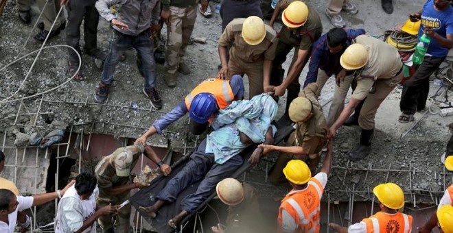 Miembros de la Fuerza de Respuesta de Desastres Nacionales (NDRF) trabajan para rescatar a las víctimas del derrumbe en Calcuta. - EFE