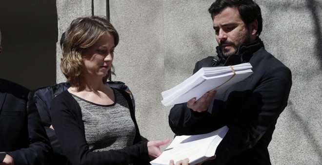 El portavoz de IU en el Congreso, Alberto Garzón, y la eurodiputada Marina Albiol muestran la querella que han presentado en el Tribunal Supremo contra el presidente del Gobierno en funciones, Mariano Rajoy, por un presunto delito de 'crímenes de lesa hum