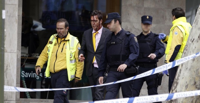 Agentes del Grupo Especial de Operaciones (GEO) junto a un herido del secuestro de una clínica dental de la avenida del Mediterráneo de Madrid, donde varias personas permanecen retenidas por varias personas que pretendían atracar el local. EFE/J.J.Guillen