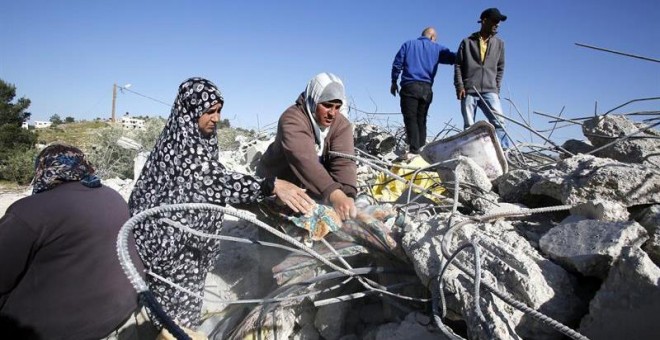 Una familia palestina busca sus pertenencias entre las ruinas de su casa después de que el ejército israelí destruyera su casa en Soureef, cerca de Hebrón. - EFE