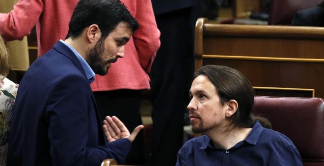 El diputado de IU-Unidad Popular, Alberto Garzón, conversa con el líder de Podemos, Pablo Iglesias, durante la sesión constitutiva del Congreso.-REUTERS