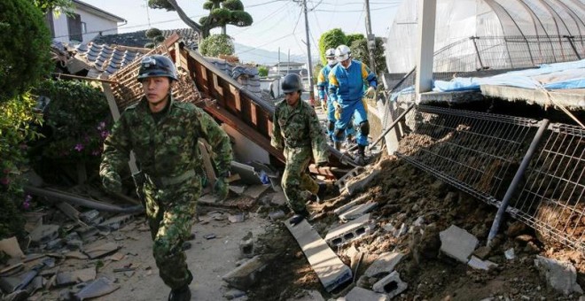 Militares japoneses entre los restos de una casa que ha sufrido las consecuencias de los temblores. - EFE