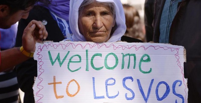 Una mujer sujeta una pancarta de bienvenida al Papa en el centro de detención de Moria. - EFE