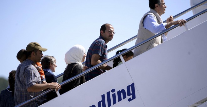Los refugiados sirios retenidos en Lesbos suben al avión con dirección a Roma. REUTERS/Filippo Monteforte/Pool