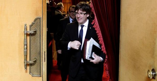 El presidente de la Generalitat, Carles Puigdemont, abandona el hemiciclo del Parlament de Catalunya, tras la sesión de control al gobierno que se ha producido pocas horas antes de que el presidente catalán se reúna en la Moncloa con el presidente del Gob