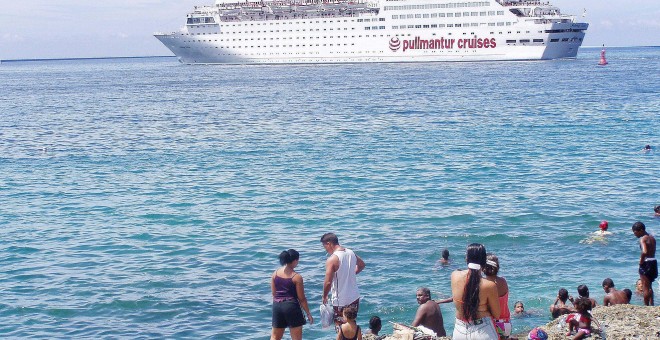 Ciudadanos cubanos contemplan un crucero desde la costa de la isla.