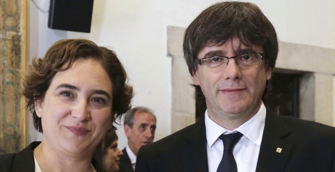 Carles Puigdemont, junto a la alcaldesa de Barcelona, Ada Colau, tras regalarle la tradicional rosa, con motivo de la festividad de Sant Jordi. EFE/Ruben Moreno