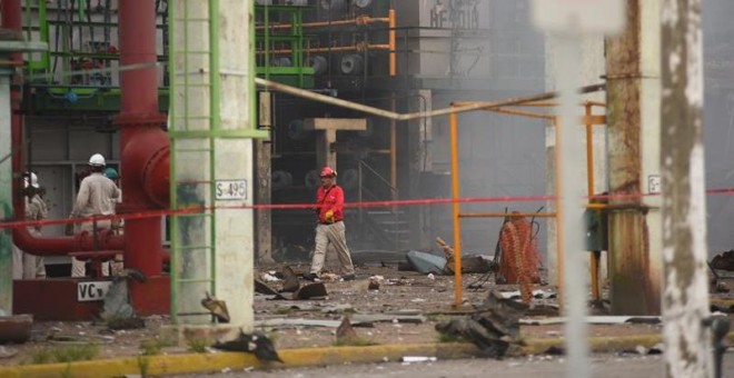 Trabajadores caminan en la zona afectada por una explosión en la empresa Petroquímica Mexicana de Vinilo (PMV). EFE/Ángel Hernández