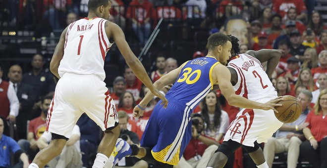Stephen Curry conduce el balón ante dos jugadores de los Houston Rockets. /REUTERS