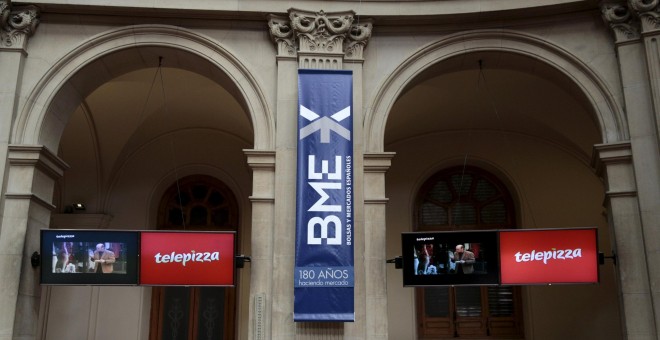 El logo de Telepizza en los monitores del patio de contratación de la Bolsa de Madrid el día de su reestreno en el parqué. REUTERS/Andrea Comas