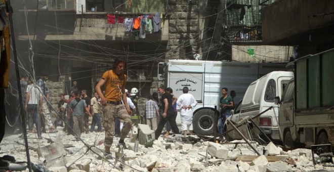Varias personas se reúnen en el lugar donde se han producido ataques aéreos en el barrio Kalasa de Alepo. - EFE