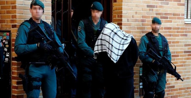 Uno de los presuntos integrantes de un organización encargada de la captación y adoctrinamiento de yihadistas es detenido por miembros de la Guardia Civil. EFE/Sergio Barrenechea