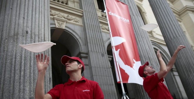 Los trabajadores de Telepizza lanzan la masa al aire en una demostración en la Bolsa de Madrid el primer día de cotización de la empresa.. REUTERS/Andrea Comas