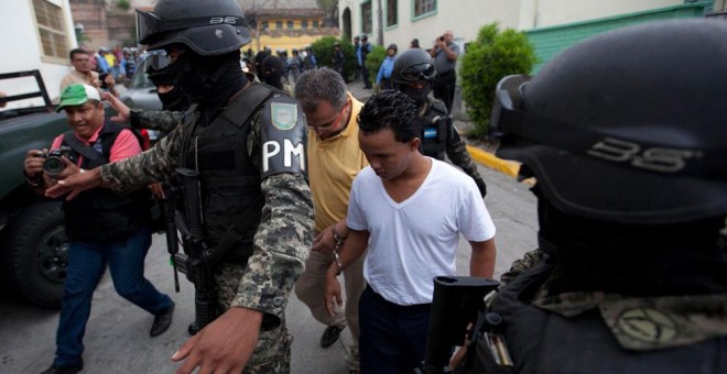 Policías militares custodian a Sergio Rodríguez Orellana y Edilson Duarte, dos de los cuatro supuestos implicados en el asesinato, el 3 de marzo pasado en Honduras, de la ambientalista y defensora de derechos humanos Berta Cáceres. EFE/Gustavo Amador